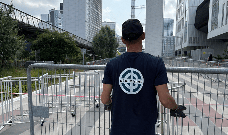 Personne transportant une barrière dans une allée piétonne